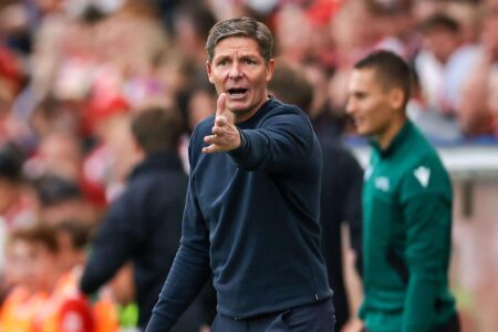 دين هندرسون، قائد كريستال بالاس، يتحدث إلى وسائل الإعلام بتعبير جاد، مع شعار دوري المؤتمر الأوروبي في الخلفية.